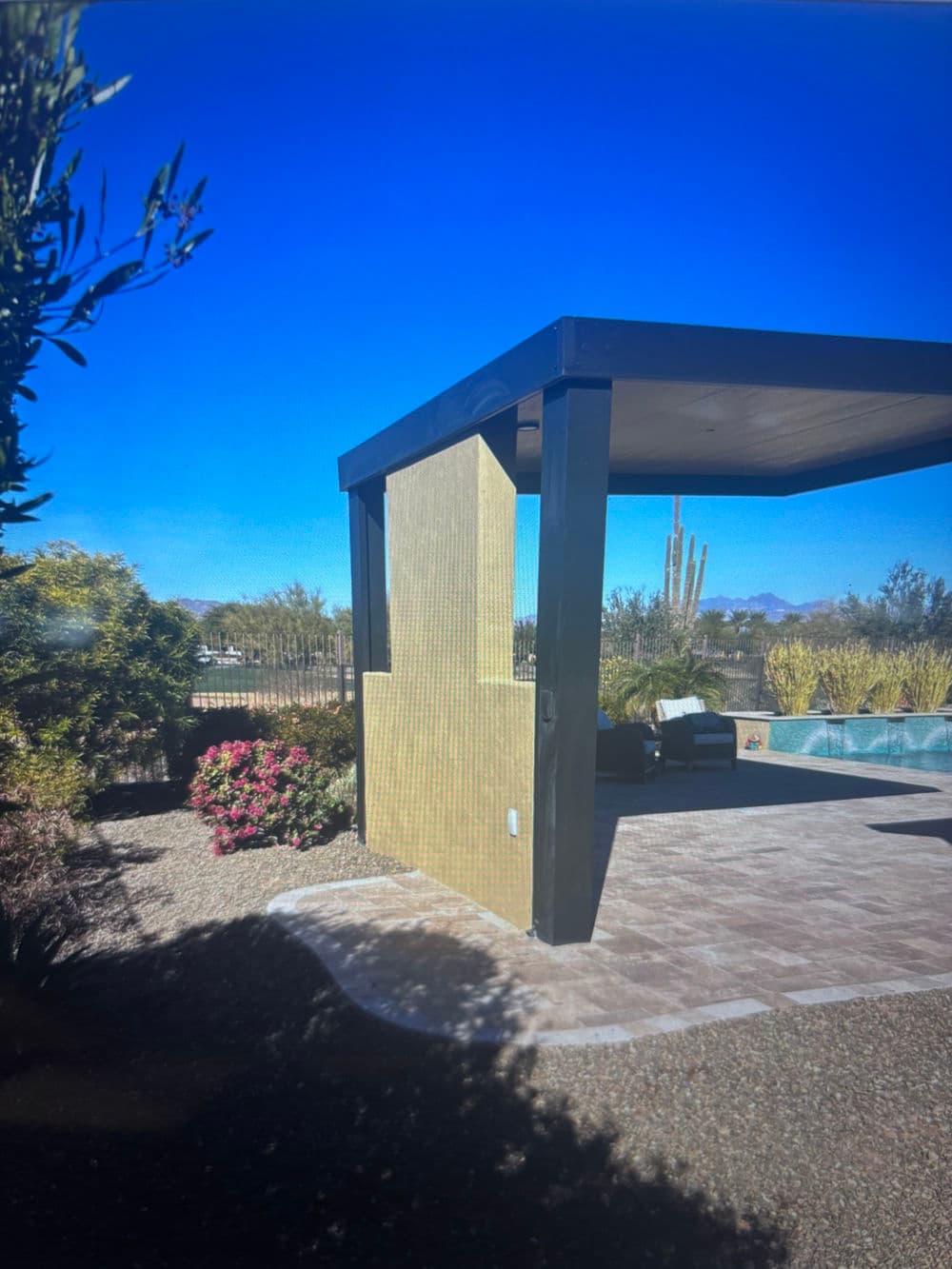 Stylish outdoor pavilion with desert landscaping and clear blue sky.