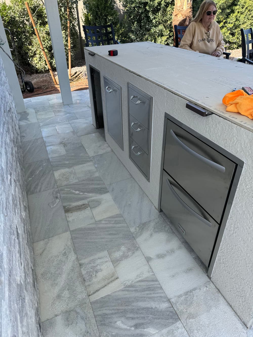 Outdoor kitchen featuring stainless steel cabinets and modern tile flooring.