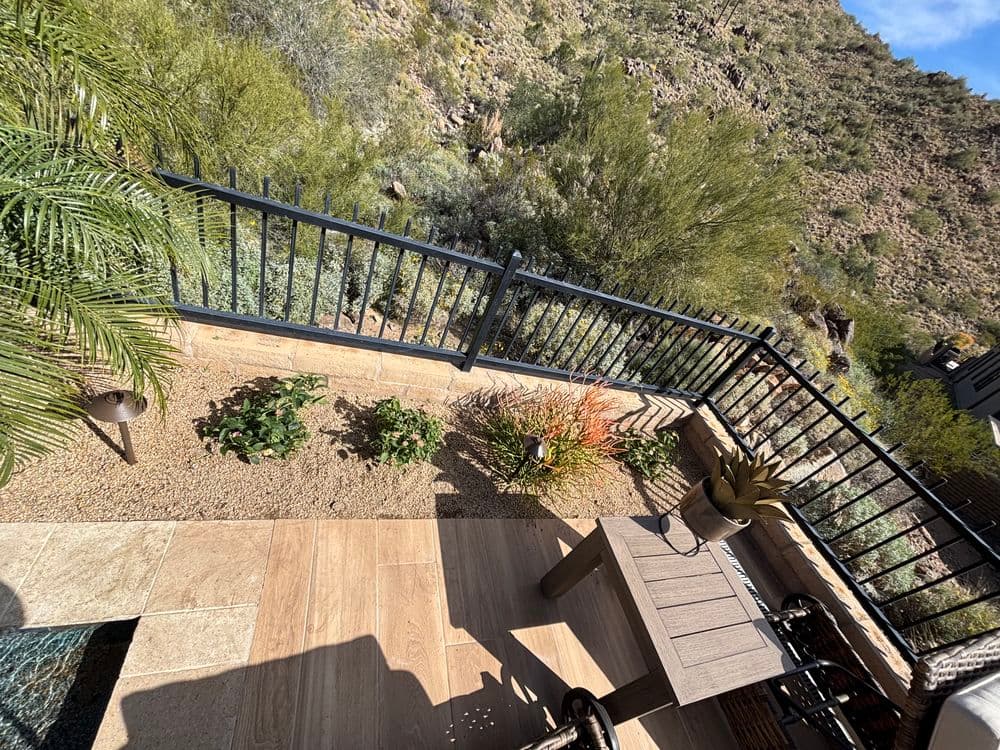 Desert view from balcony with plants, patio furniture, and mountain backdrop.